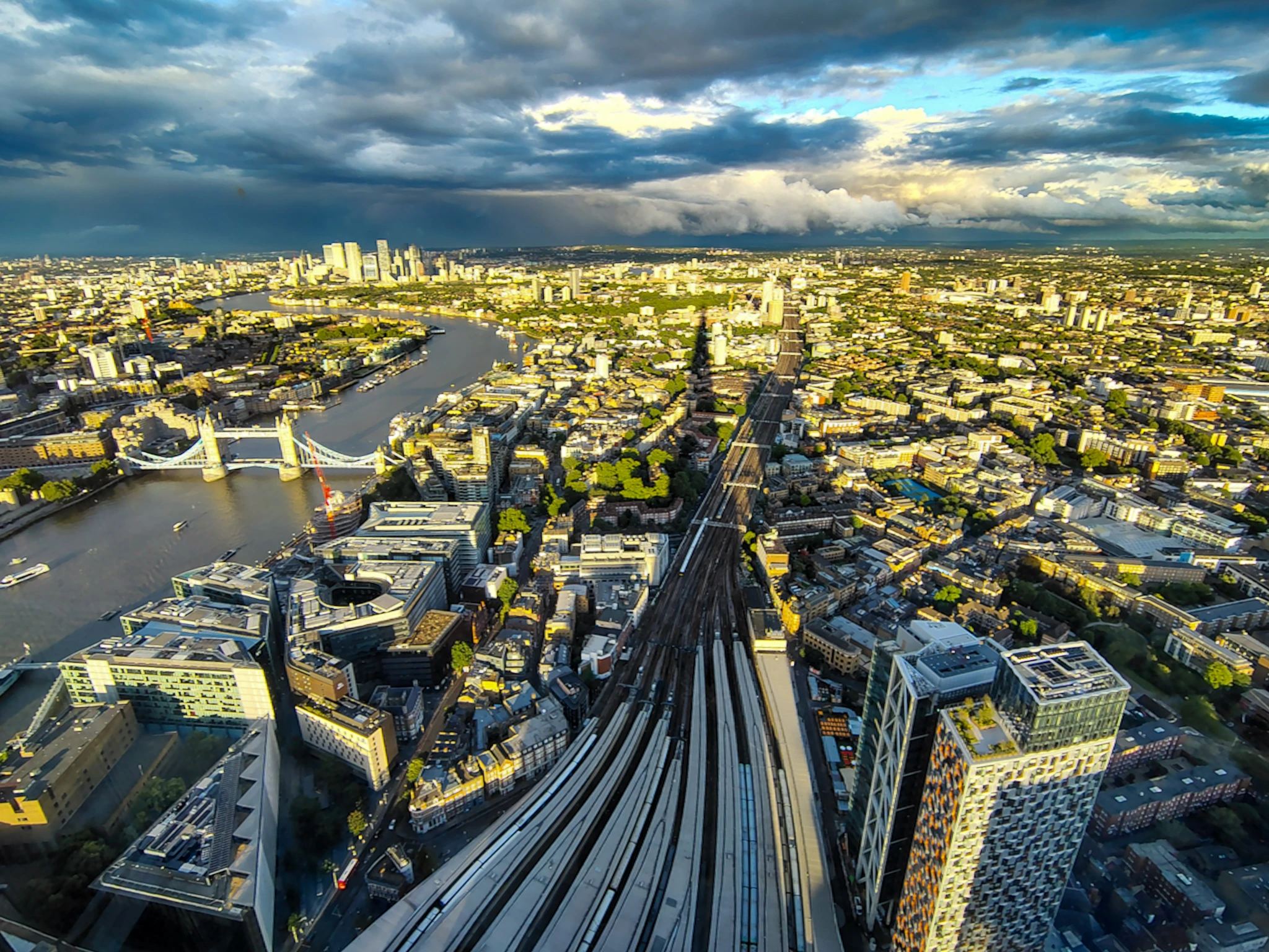 Szeroki widok z tarasu The Shard obejmuje Tower Bridge, Tamizę, tory kolejowe i wschodnie dzielnice Londynu.